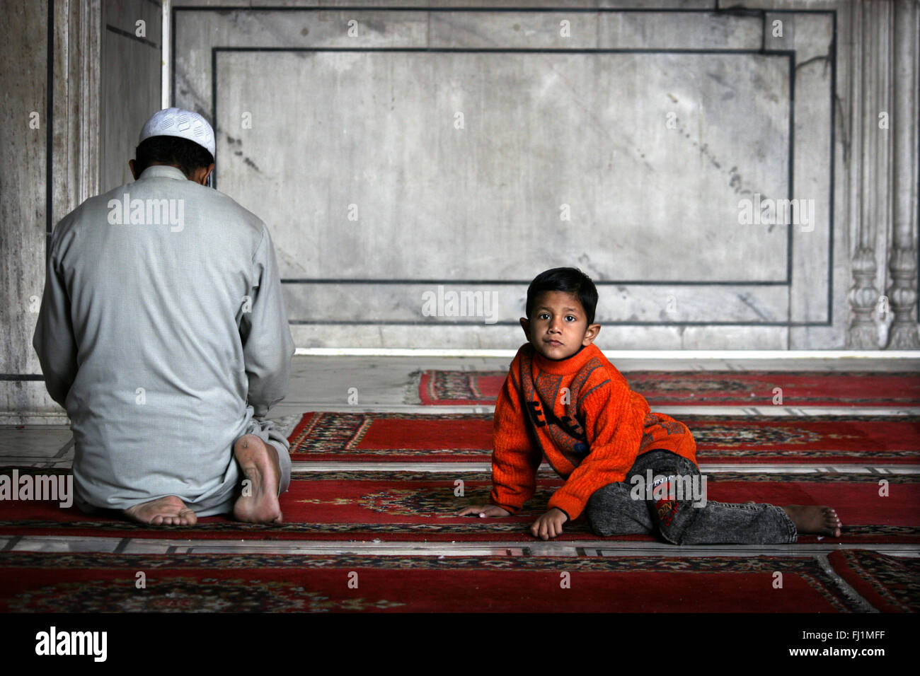 Padre musulmano e figlio di pregare presso la Jama Masjid (grande moschea) di Vecchia Delhi , India Foto Stock