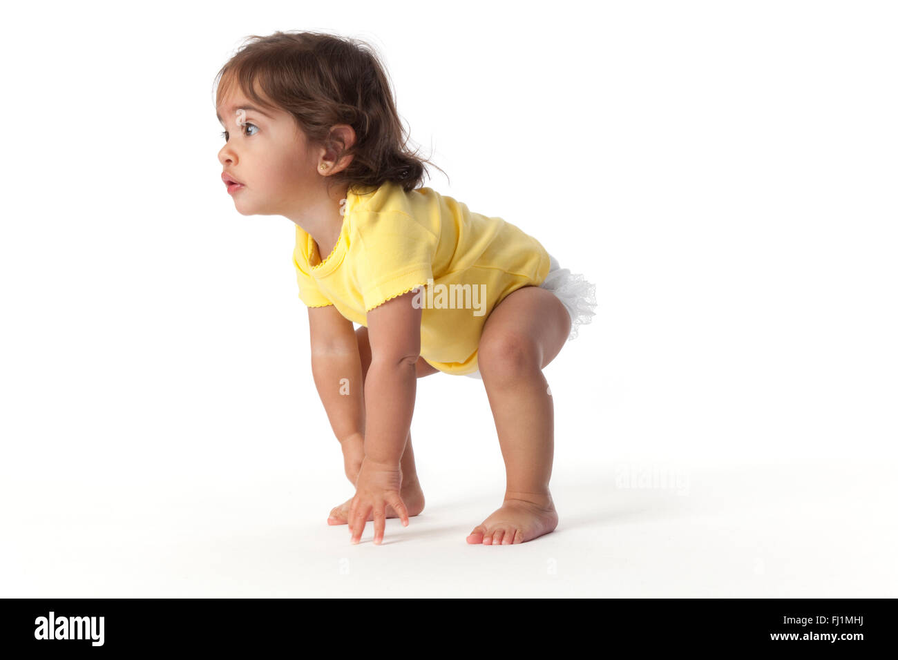 Bambina in una posizione di avvio su sfondo bianco Foto Stock