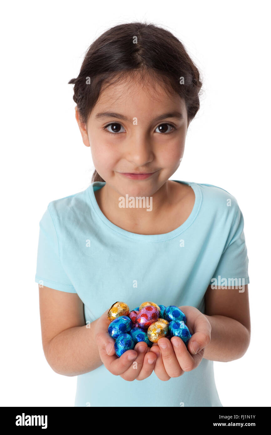 Bambina con una manciata di cioccolato uova orientale su sfondo bianco Foto Stock