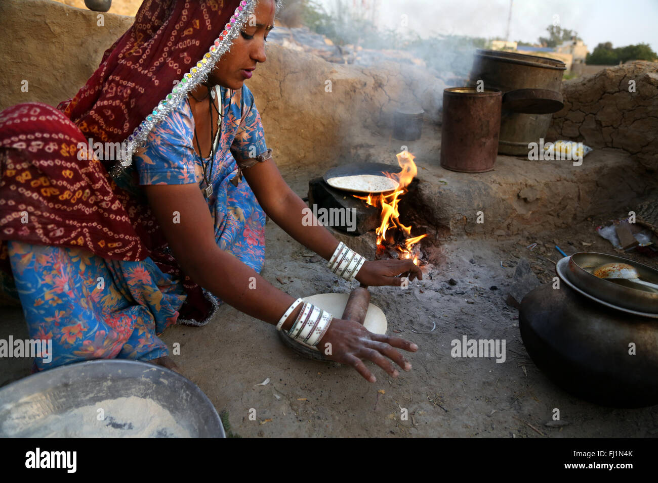 Donna indiana tradizionale cucina chapatti in Jaisalmer Rajasthan in India Foto Stock