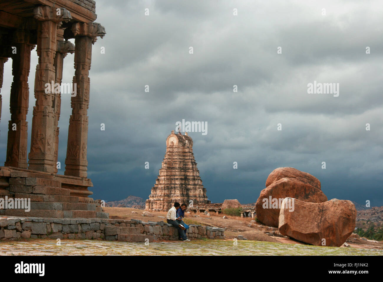 Indian giovane seduto vicino al tempio di Hampi, Karnataka Foto Stock
