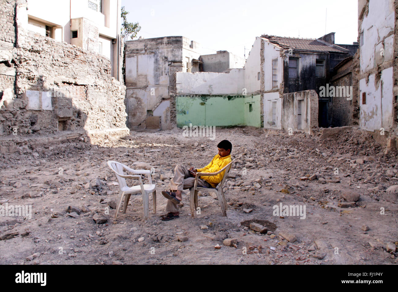 Uomo seduto da solo tra le rovine del palazzo distrutto dopo il terremoto di Bhuj, Gujarat, in India Foto Stock