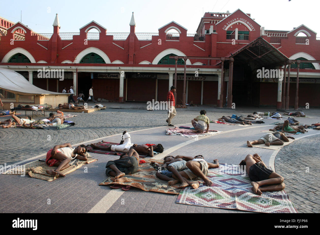 Dormire la gente ruvida in strada la mattina presto di fronte al nuovo mercato , Kolkata , India Foto Stock