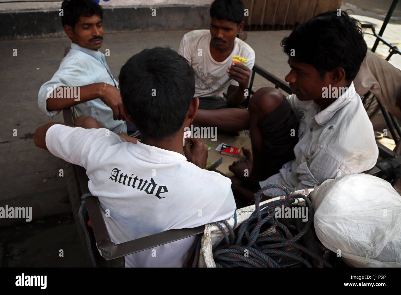 Gli uomini le carte da gioco in Kolkata, uno di loro indossa " atteggiamento " shirt Foto Stock