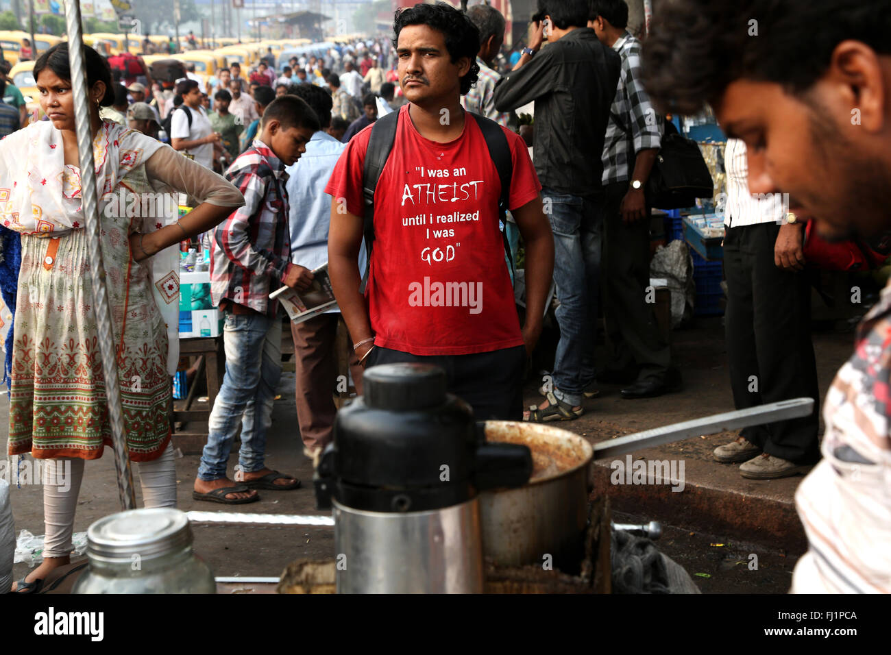 Uomo con speciale t shirt in mezzo alla folla al mattino presto di fronte alla stazione ferroviaria di Howrah , Kolkata , India Foto Stock