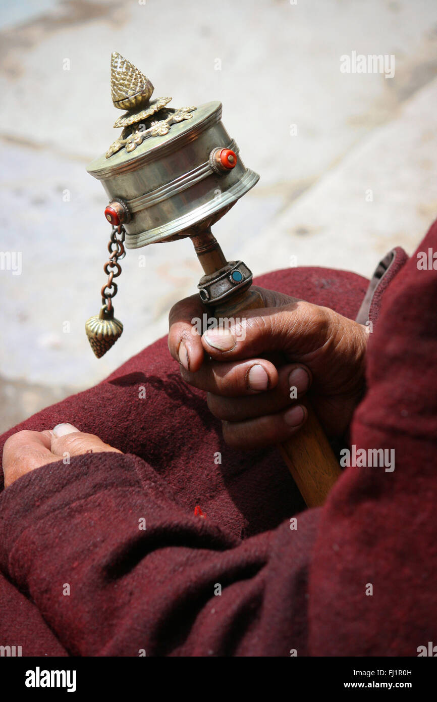 Mano di uomo con la preghiera buddista della ruota in corrispondenza Thiksey gompa monastero , Ladakh , India Foto Stock