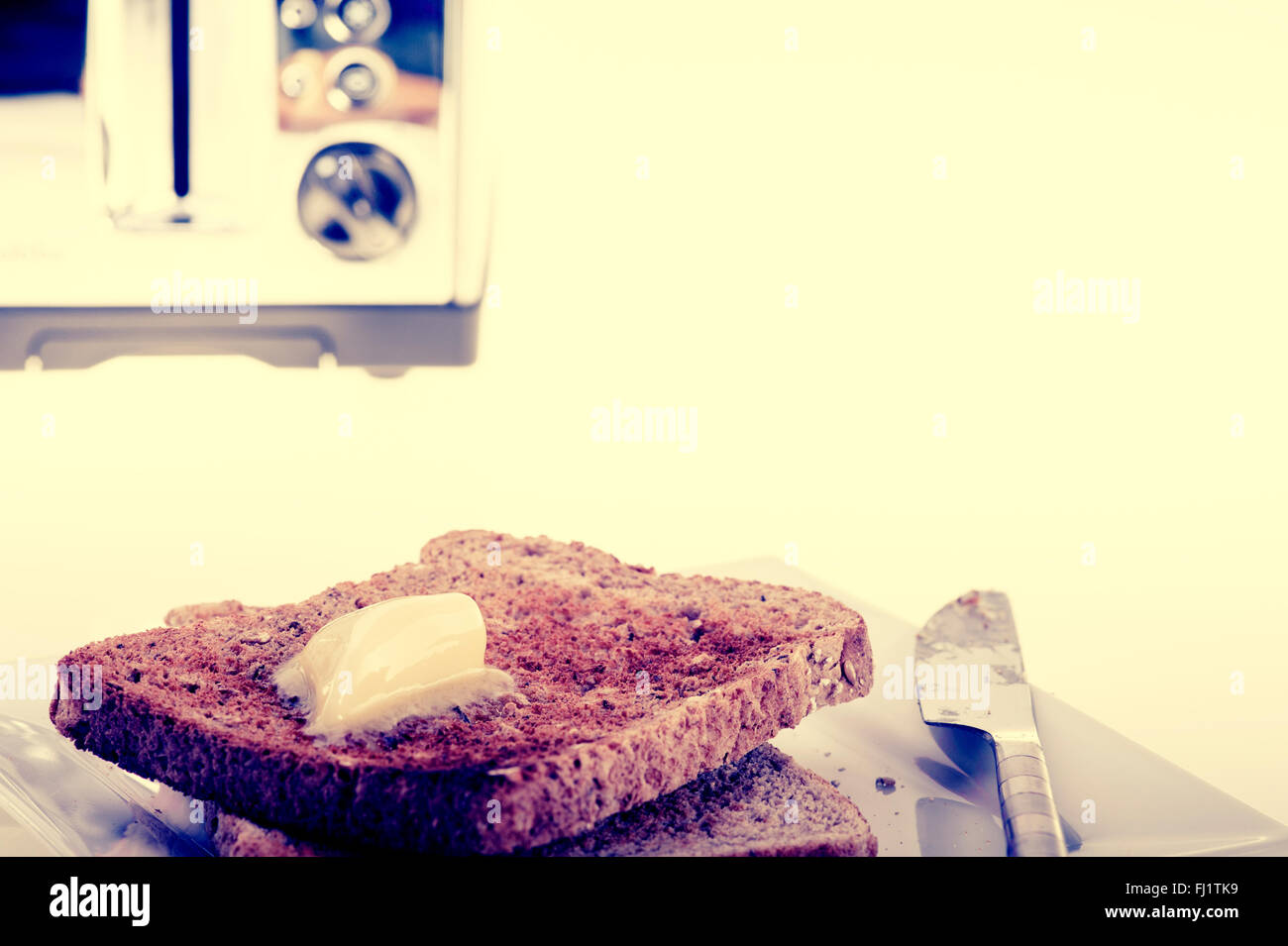 Due fette di pane tostato e burro, con croce vintage look di processo. Foto Stock