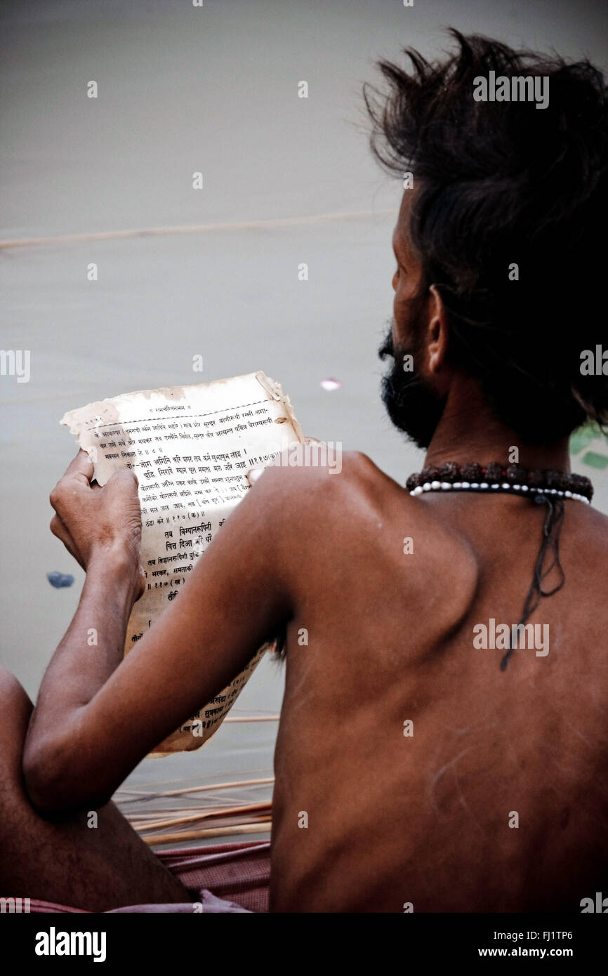 Sadhu lettura libro Sanscrita di Varanasi, India Foto Stock