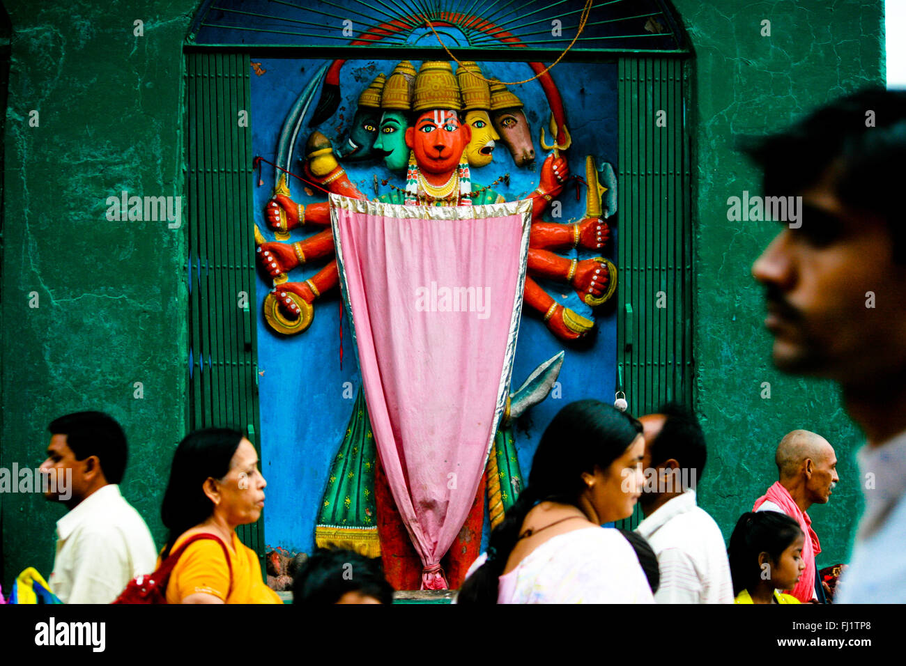 Persone che passano di fronte Hanuman temple, Varanasi, India Foto Stock
