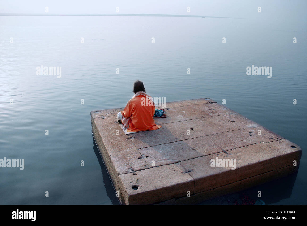 L'uomo meditando sulle rive del Gange Varanasi, India Foto Stock