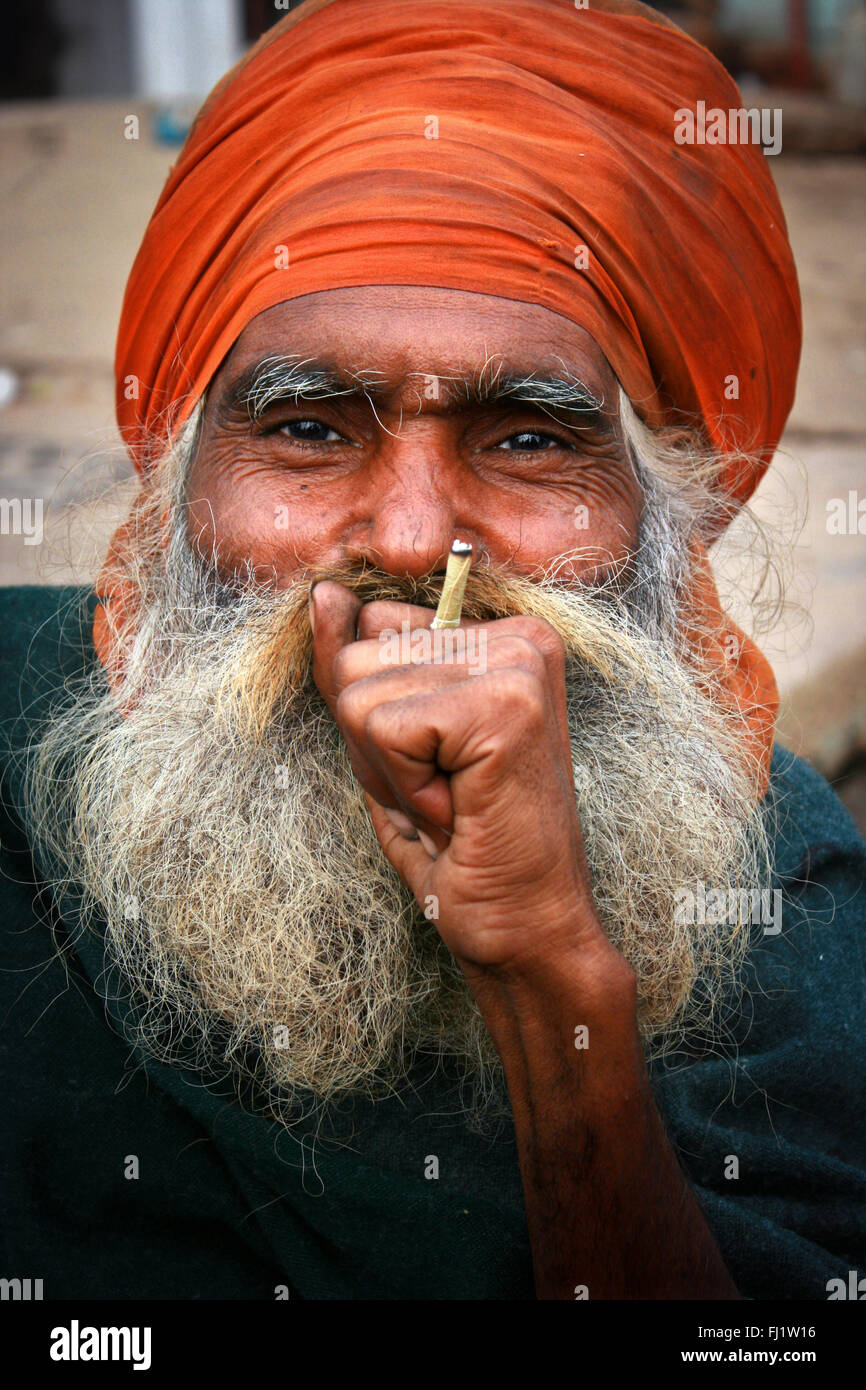 Uomo con barba e turbante Beedi fumare in Varanasi, India Foto Stock