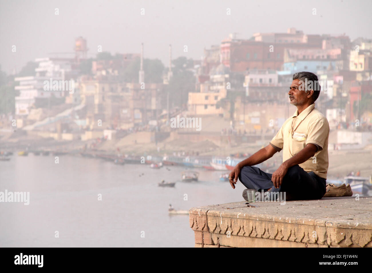 Uomo a praticare lo yoga al mattino presto in Varanasi, India Foto Stock