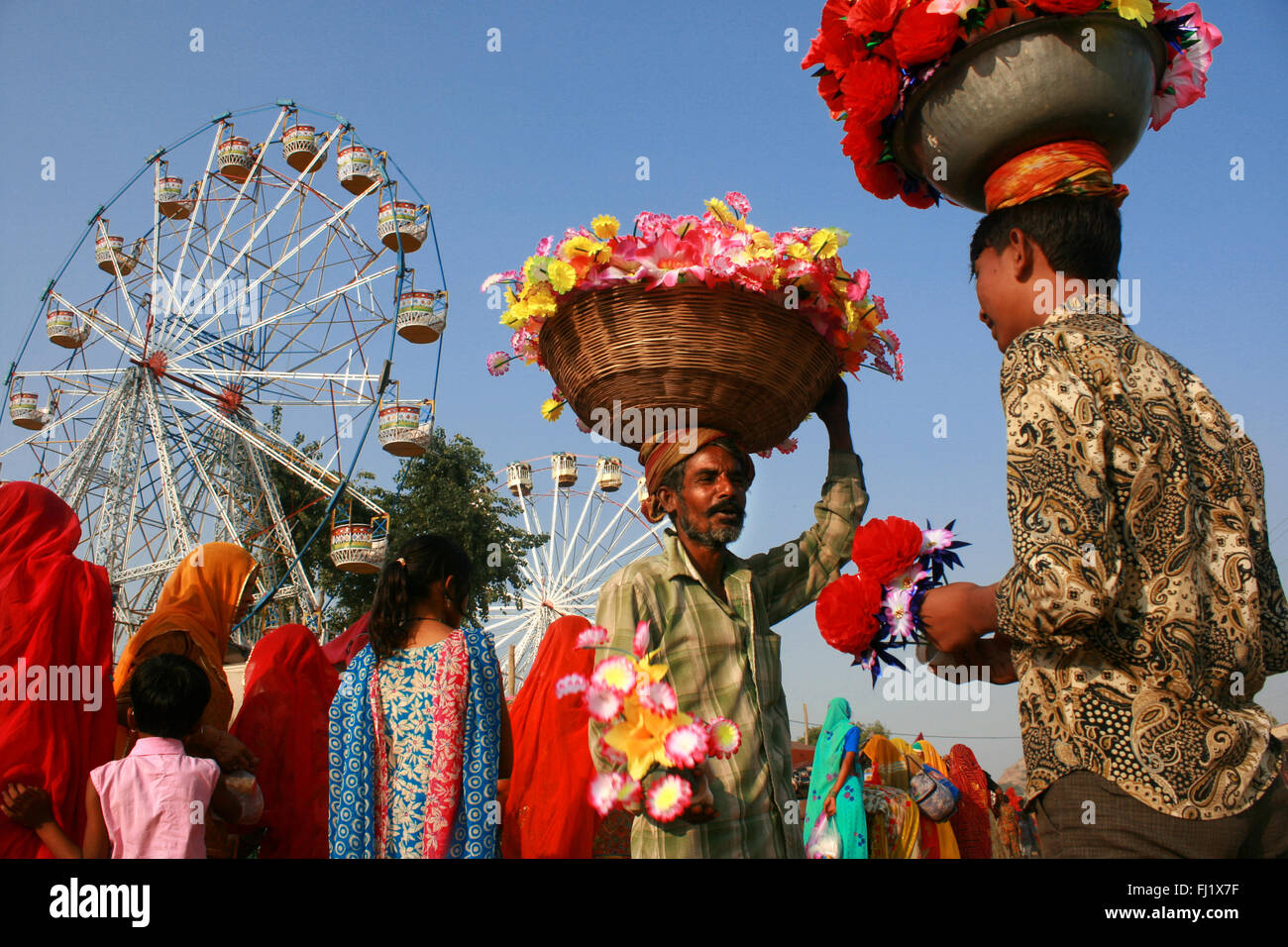 Gli uomini che vendono fiori durante il Pushkar mela camel fair , Rajasthan Foto Stock