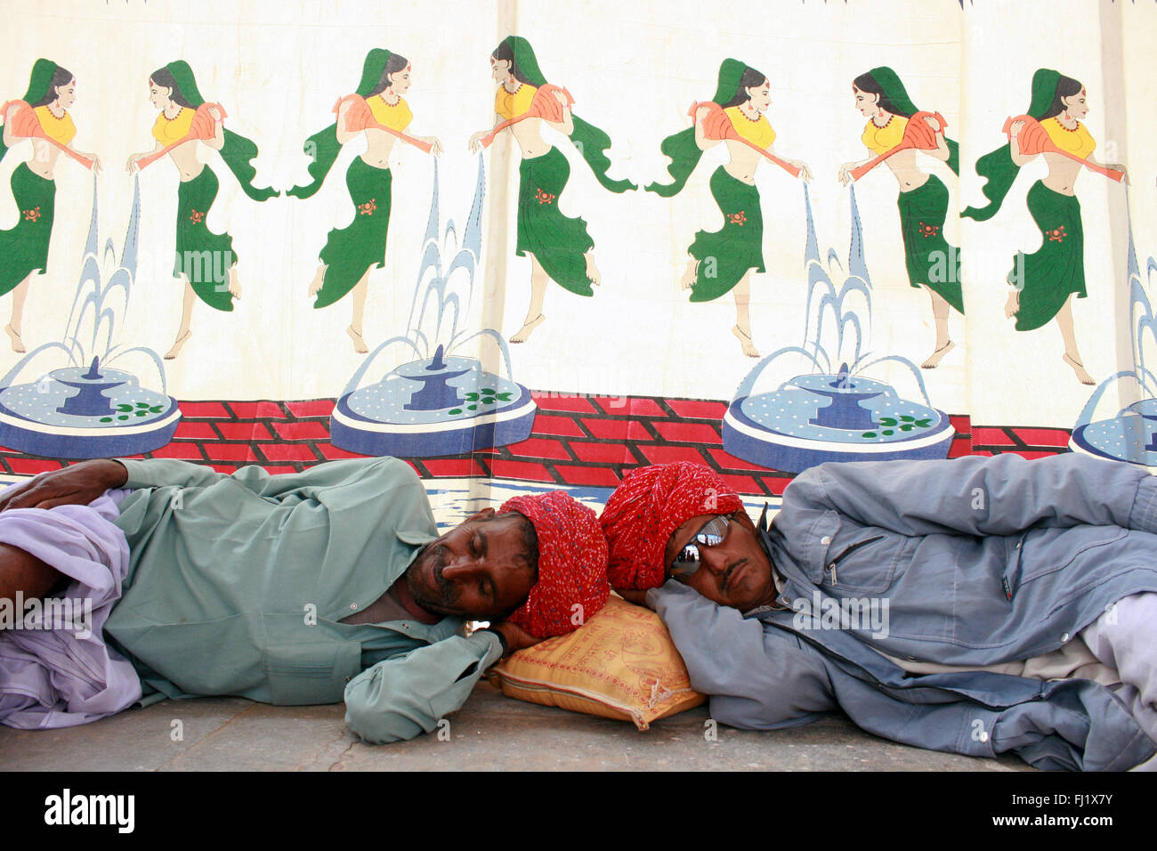 Due uomini stanno dormendo con turbante durante il Pushkar mela camel fair , Rajasthan Foto Stock