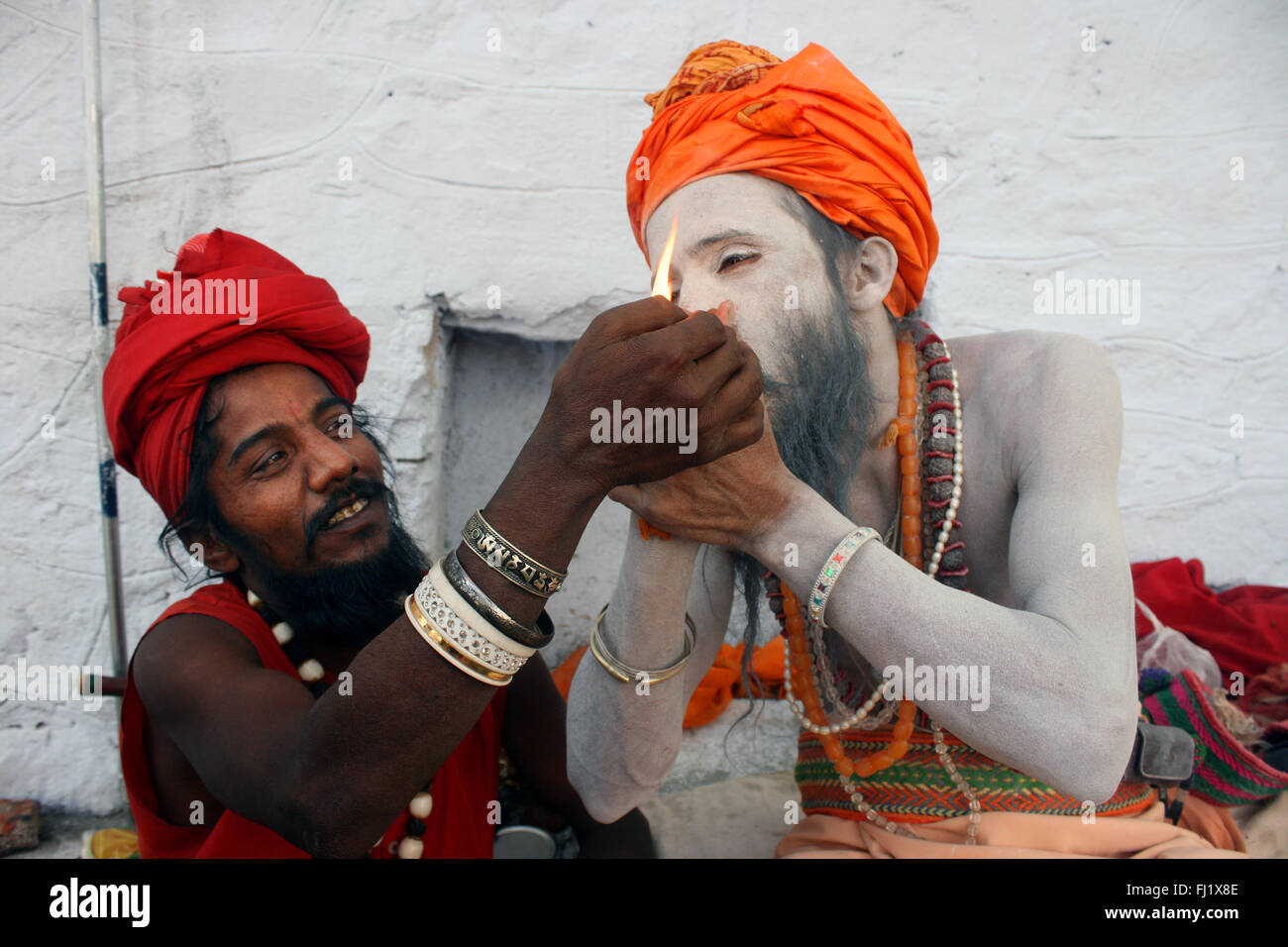 Sadhus chillum fumare durante il Pushkar mela camel fair Foto Stock