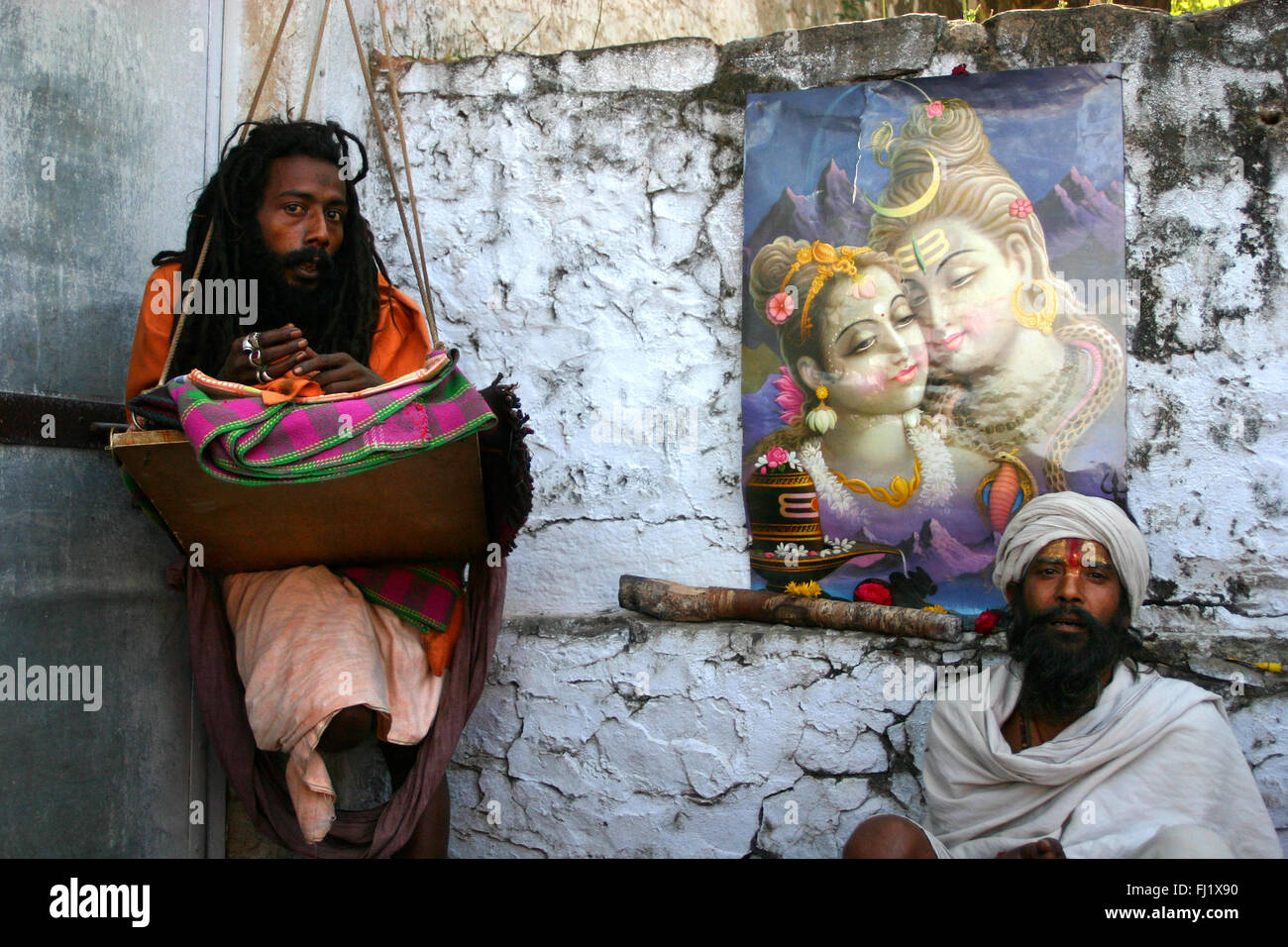 Sadhus in posa durante il Pushkar mela con poster di Shiva e Parvati Foto Stock