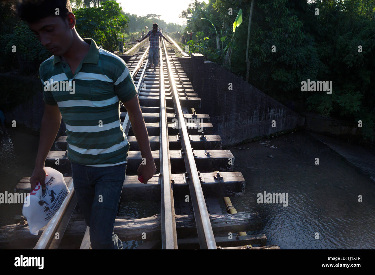 Gli uomini a piedi lungo i binari del treno / i brani in Sreemangal , Bangladesh Foto Stock