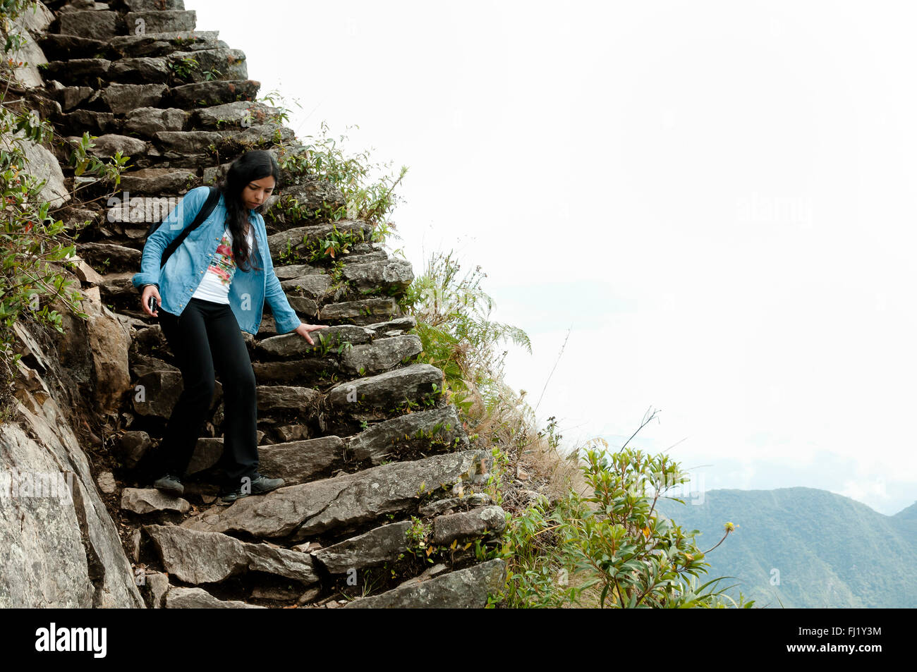Turistico latina sulla scala di roccia - Machu Picchu - Perù Foto Stock