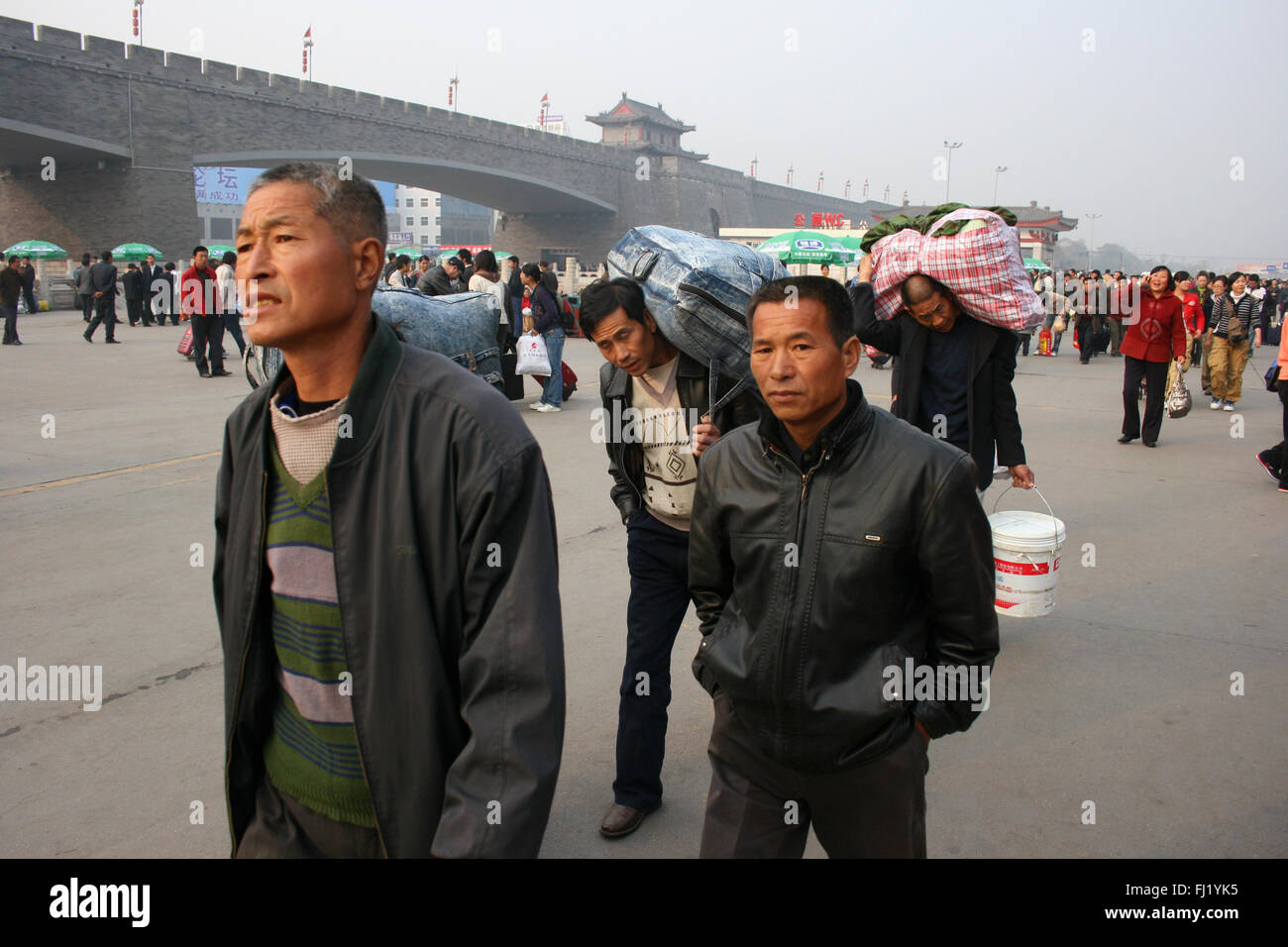 Gli uomini di passeggeri a piedi vicino a Xi'An stazione ferroviaria , Cina Foto Stock