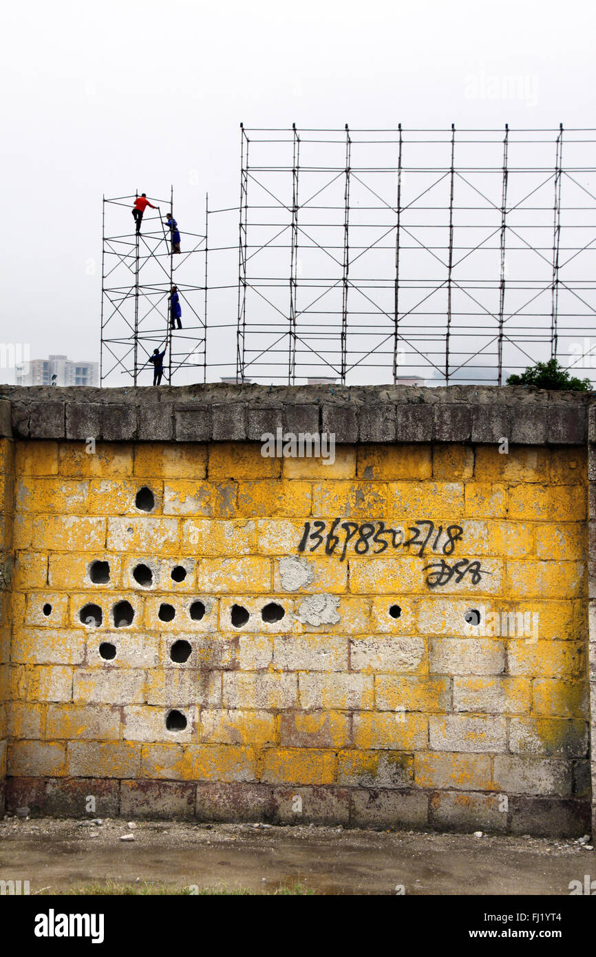 Gli uomini al lavoro, a parete con il vecchio modello, Yuanyang, nella provincia dello Yunnan , Cina Foto Stock