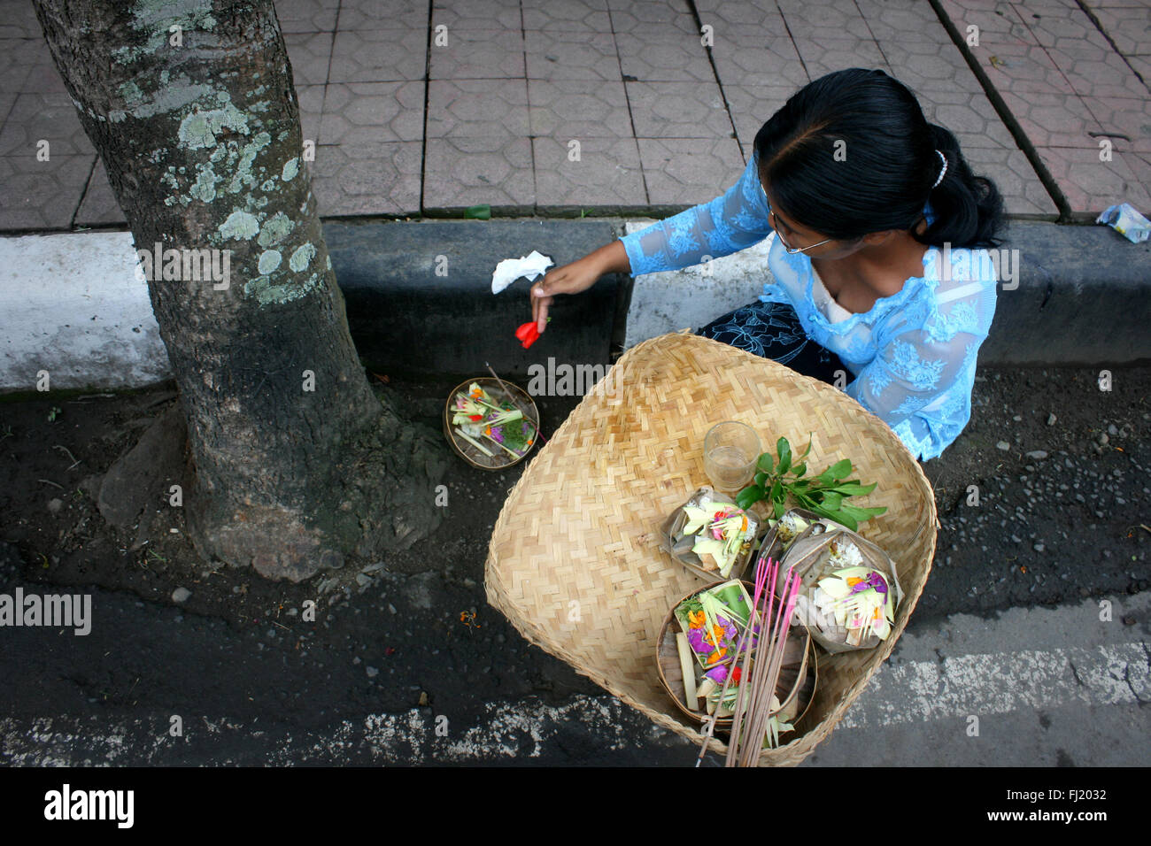 Donna che fa il rituale Indù nelle strade di Ubud , Bali , Indonesia Foto Stock