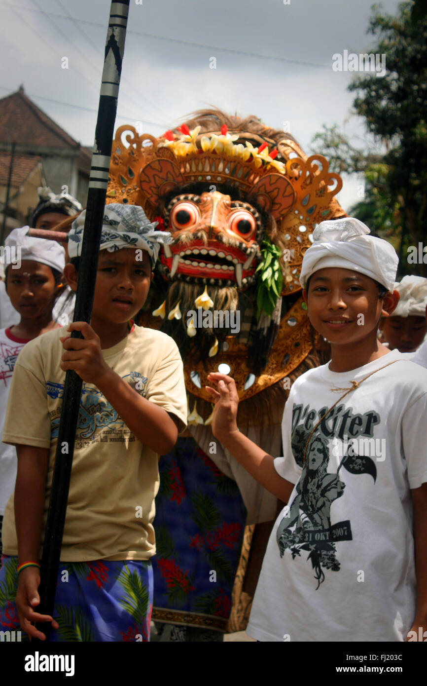 I bambini a camminare in una strada di Ubud con Barong figura, Bali , Indonesia Foto Stock