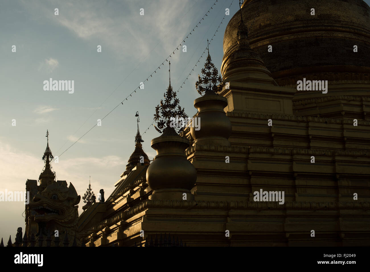 MANDALAY, Myanmar — piccoli hti decorativi (guglie a ombrello) adornano il lato di uno stupa nella Pagoda di Kuthodaw. Questi elementi ornamentali sono caratteristiche tipiche della tradizionale architettura buddista birmana. Il complesso delle pagoda, costruito nel 1857 sotto il regno di re Mindon, ospita quello che è noto come il libro più grande del mondo. Foto Stock