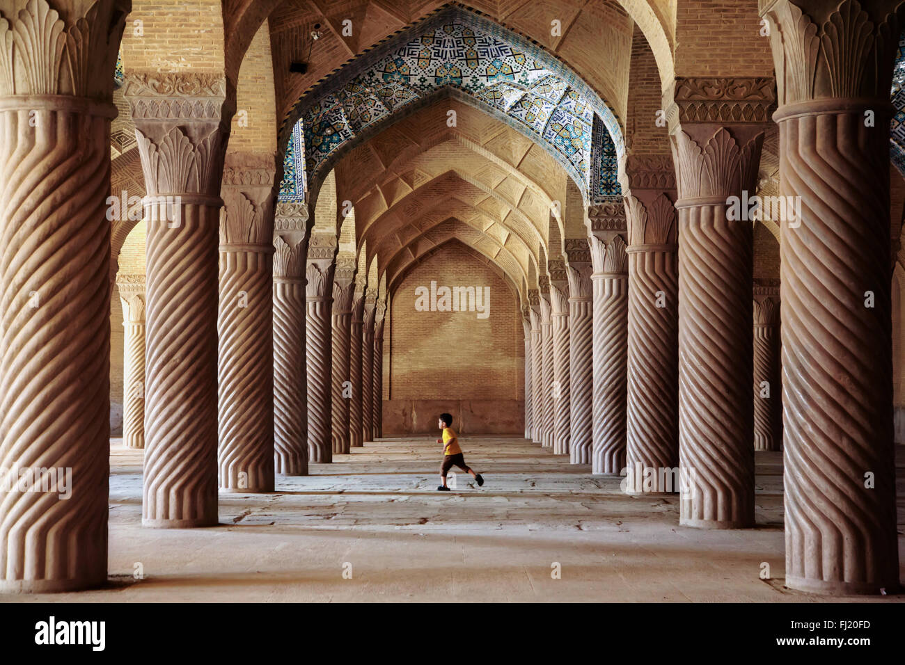Bambino in esecuzione all'interno della moschea Vakil, Shiraz, Chiraz , Iran Foto Stock