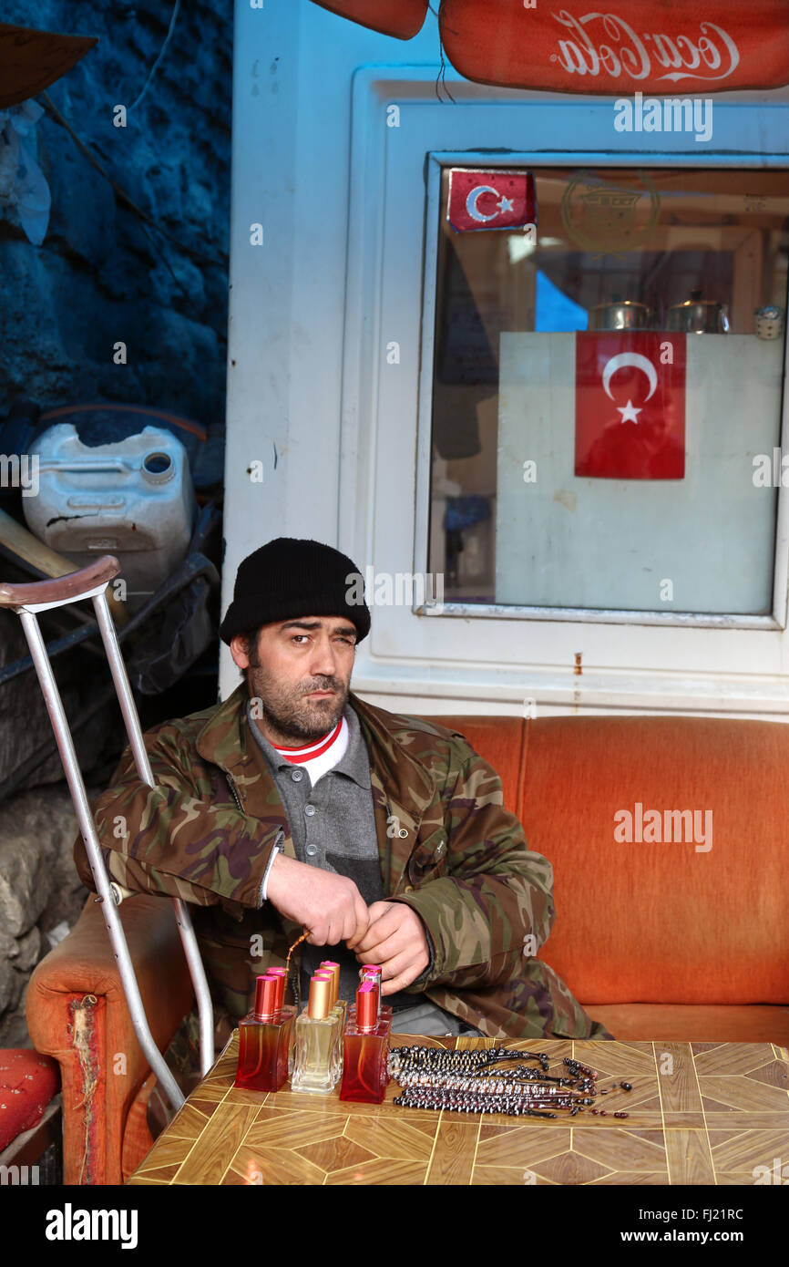 Uomo seduto con bagno turco bandiera nazionale in Istanbul , Turchia Foto Stock