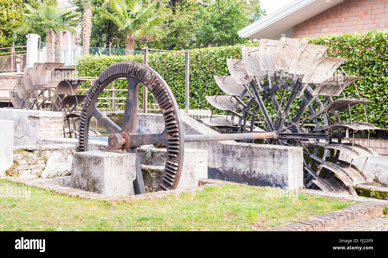 Vecchio ferro da stiro a ruota di un mulino ad acqua. Le rovine di un mulino ad acqua. Foto Stock