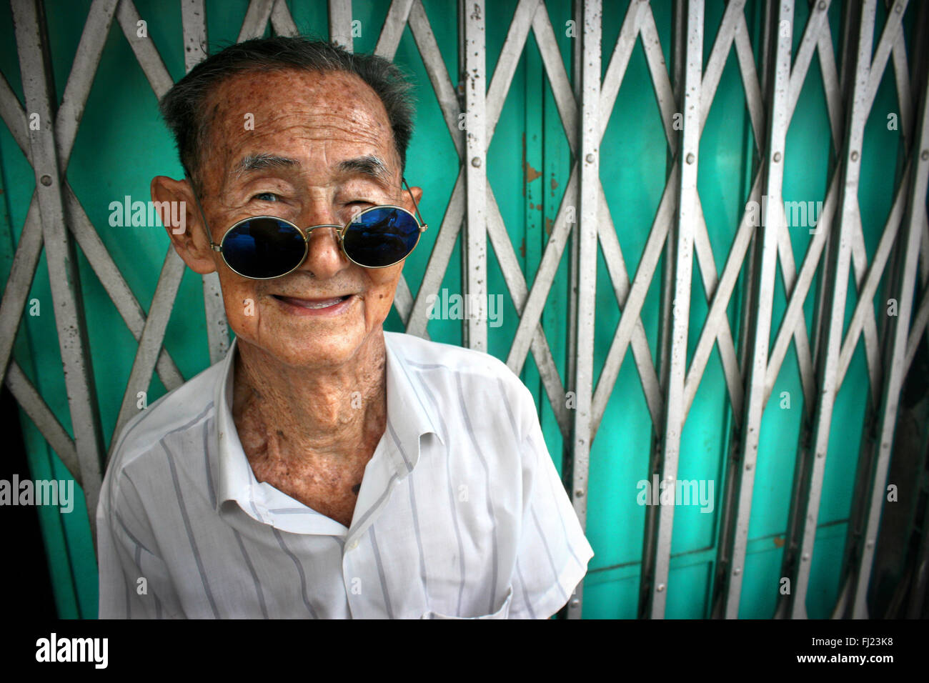 Uomo con occhiali da sole per le strade di George Town, Penang, Malaysia Foto Stock