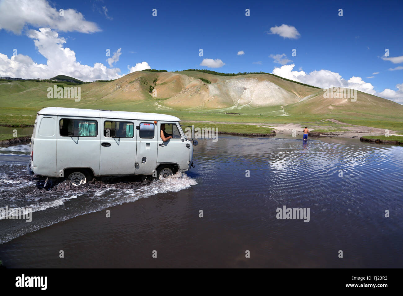 Vecchio van russi in viaggio in Mongolia attraverso un fiume e nel bel mezzo del nulla Foto Stock
