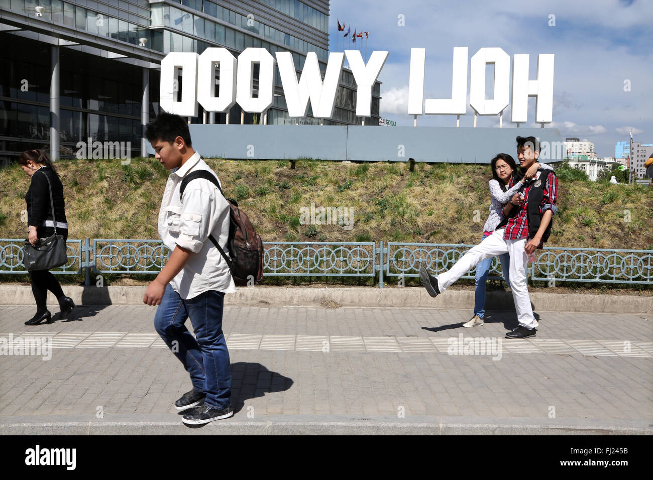 Le persone camminare per le strade di Ulanbataar con enormi lettere 'Hollywood' Foto Stock