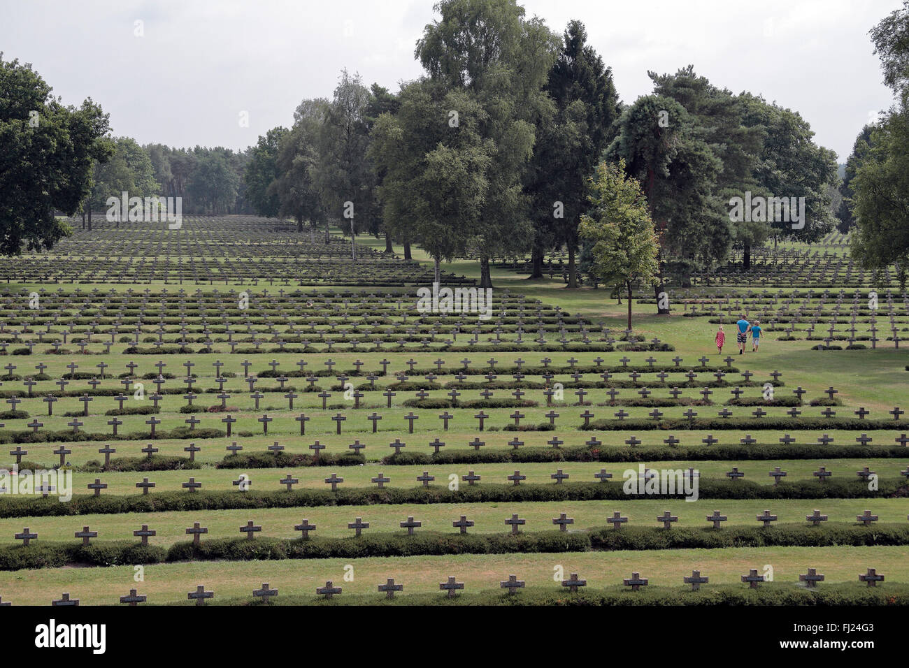 Una famiglia a piedi attraverso le molte croci/lapidi di Lommel il cimitero di guerra tedesco, Lommel, Belgio. Foto Stock