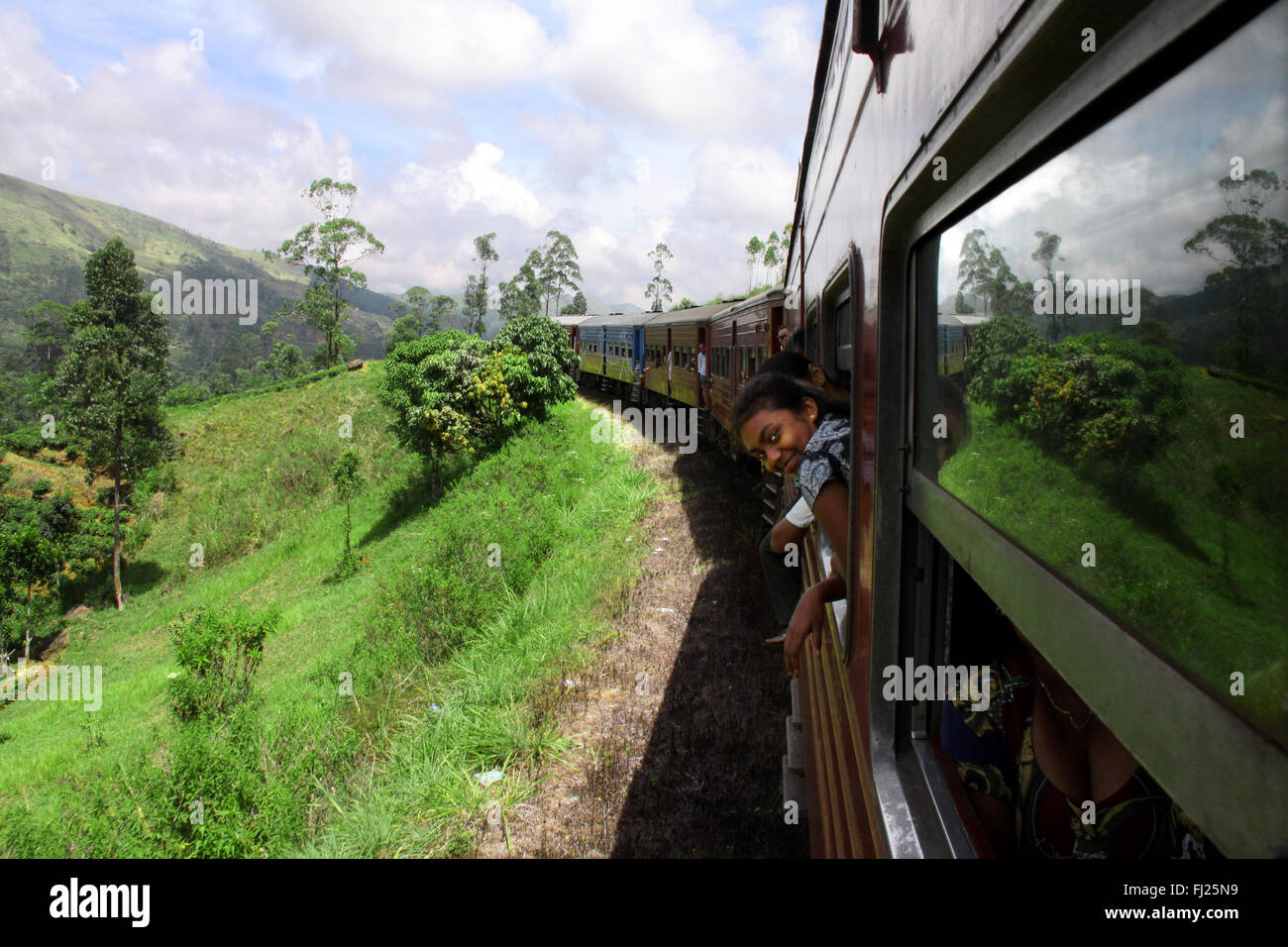 Sulla strada di un treno in verde dello Sri Lanka nel mezzo dell'isola Foto Stock
