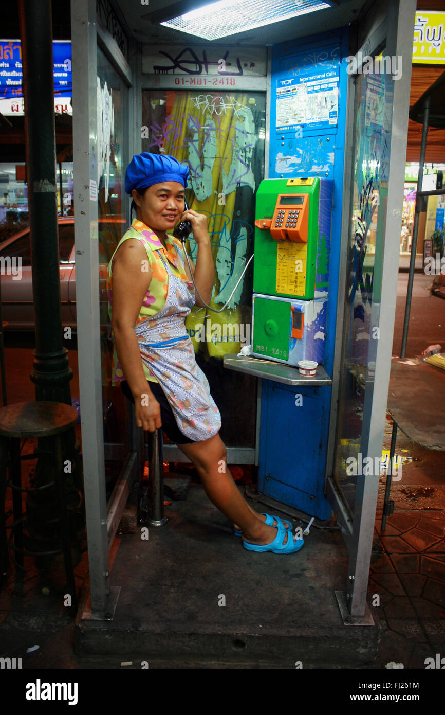 Donna al telefono nella casella Telefono Streetlife - La vita notturna a Bangkok, in Thailandia Foto Stock