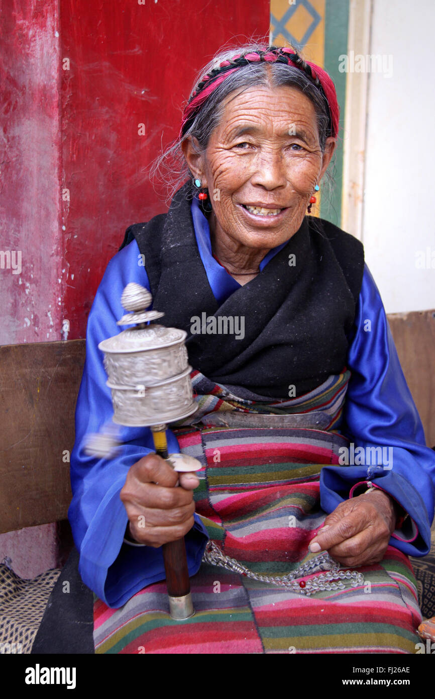 Ritratto di donna tibetana con ruota di preghiera a Lhasa, in Tibet Foto Stock