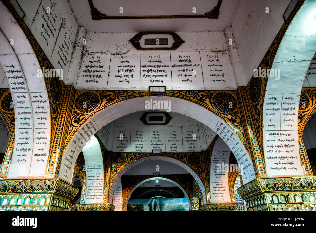Sutaungpyei Pagoda Donor Inscriptions Mandalay Myanmar // MANDALAY, Myanmar — le iscrizioni dei donatori coprono gli archi e il soffitto del portico fuori dal santuario della Pagoda di Sutaungpyei (nota anche come su Taung Pyae Pagoda) sulla collina Mandalay. Le iscrizioni riportano i nomi dei benefattori che hanno contribuito alla costruzione e alla manutenzione della pagoda, seguendo la tradizionale pratica buddista di fare meriti attraverso donazioni religiose. La Pagoda di Sutaungpyei si trova in cima alla collina Mandalay, uno dei luoghi di pellegrinaggio più significativi del Myanmar. La pagoda fu costruita durante la metà del XIX secolo Foto Stock
