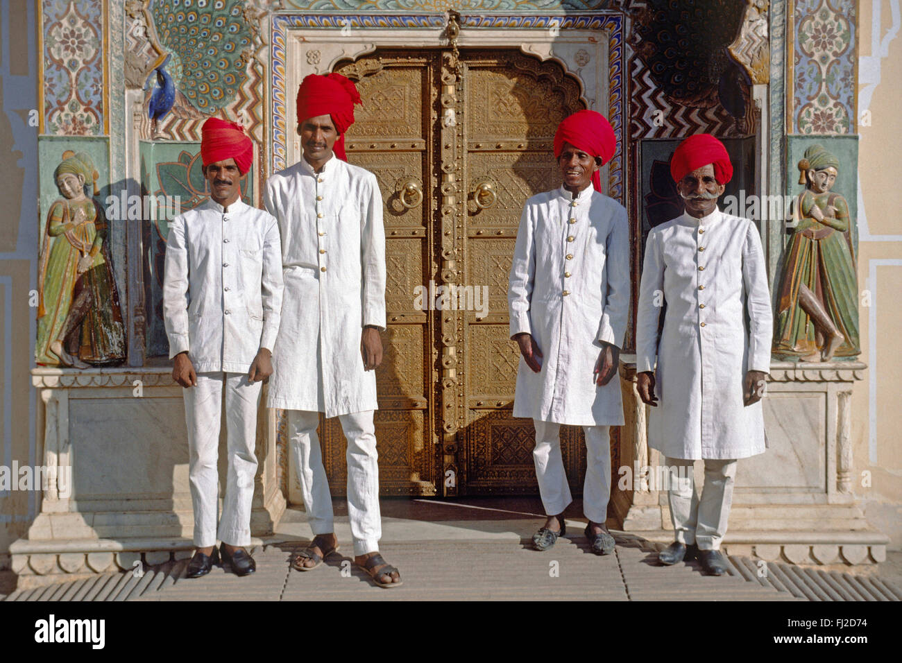 Le protezioni di Rajasthani stand al di sotto di un intagliati e dipinti PEACOCK porta presso il palazzo della città di Jaipur - Rajasthan, India Foto Stock