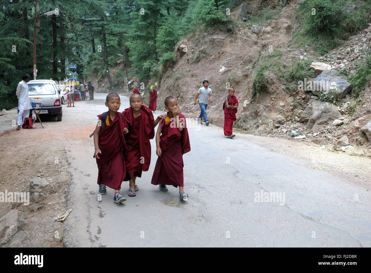 Bambino di tre monaci tibetani camminare insieme sulla strada vicino a McLeod Ganj India Foto Stock