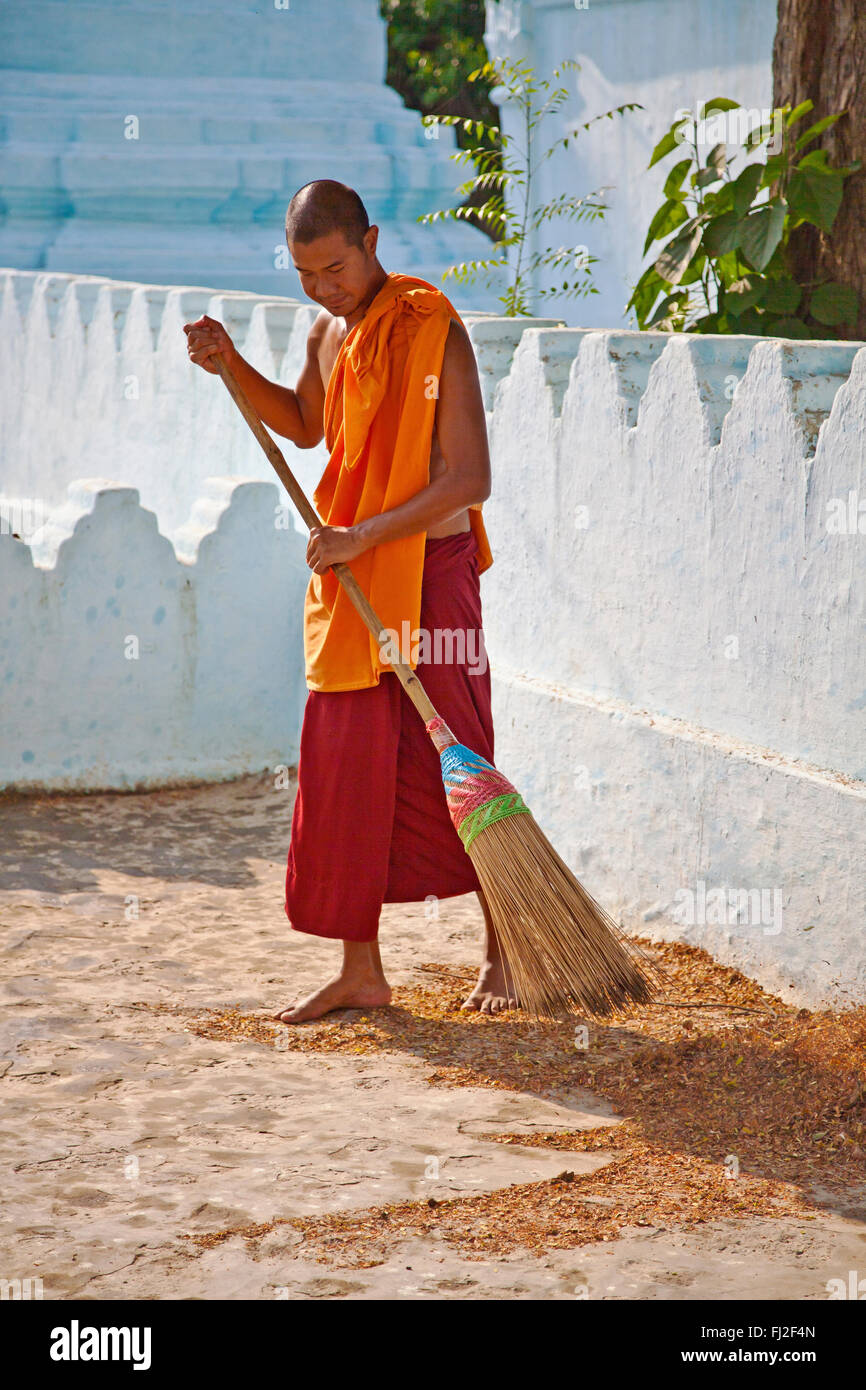 Un monaco pulisce i motivi di TAUNG MIN GYI pagoda in AMARAPURA la vecchia capitale reale 11 chilometri da MANDALAY - Myanmar Foto Stock