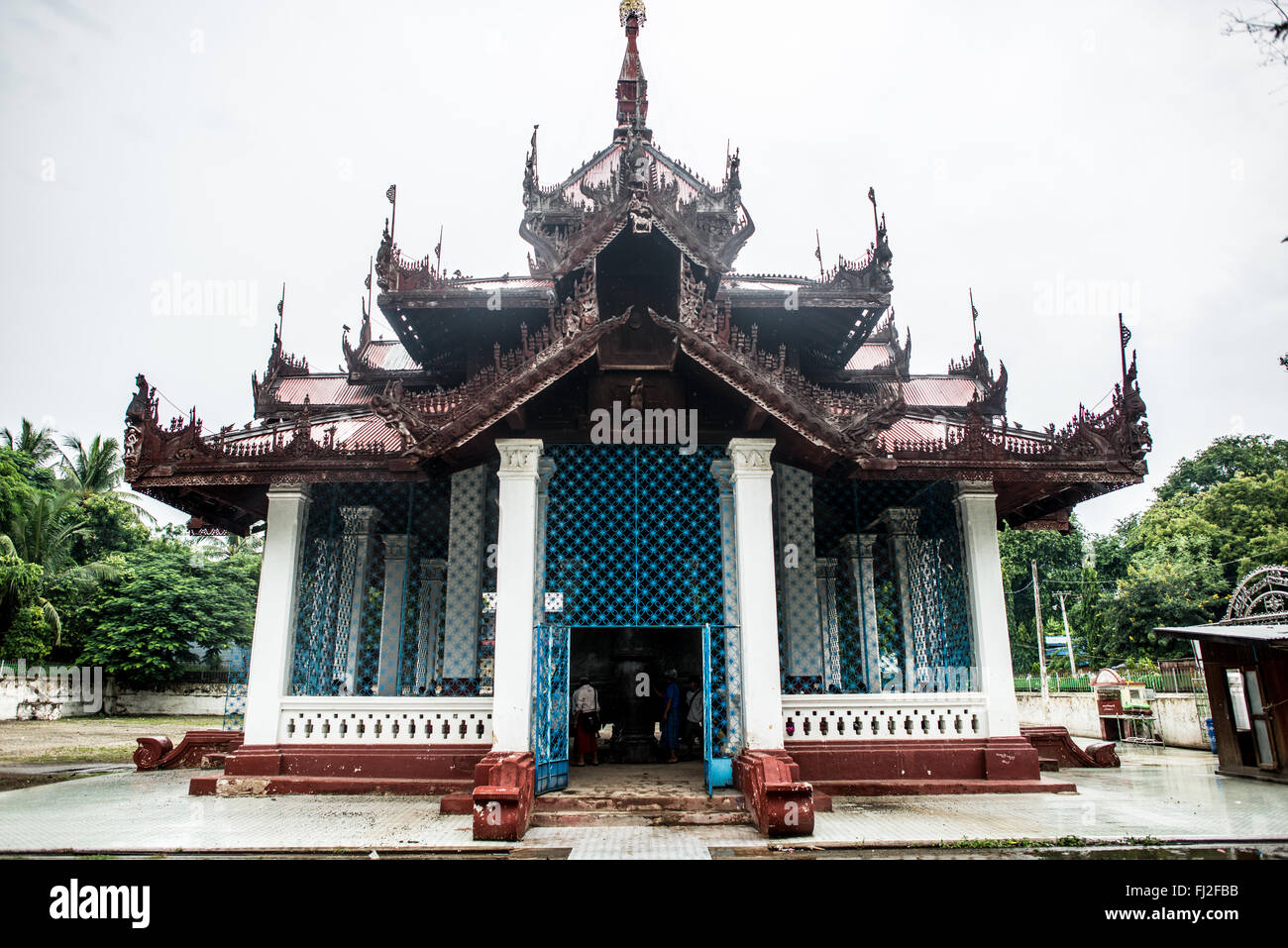 MINGUN, Myanmar - l'imponente campana di Mingun è appesa nel suo padiglione vicino a Mingun, Myanmar. Realizzata nel 1808 e con un peso di 90 tonnellate, è la campana che suona più grande del mondo. I visitatori si trovano sotto l'enorme campana di bronzo, che si erge su di loro a un'altezza di 3 metri e di 16 metri di diametro. Foto Stock