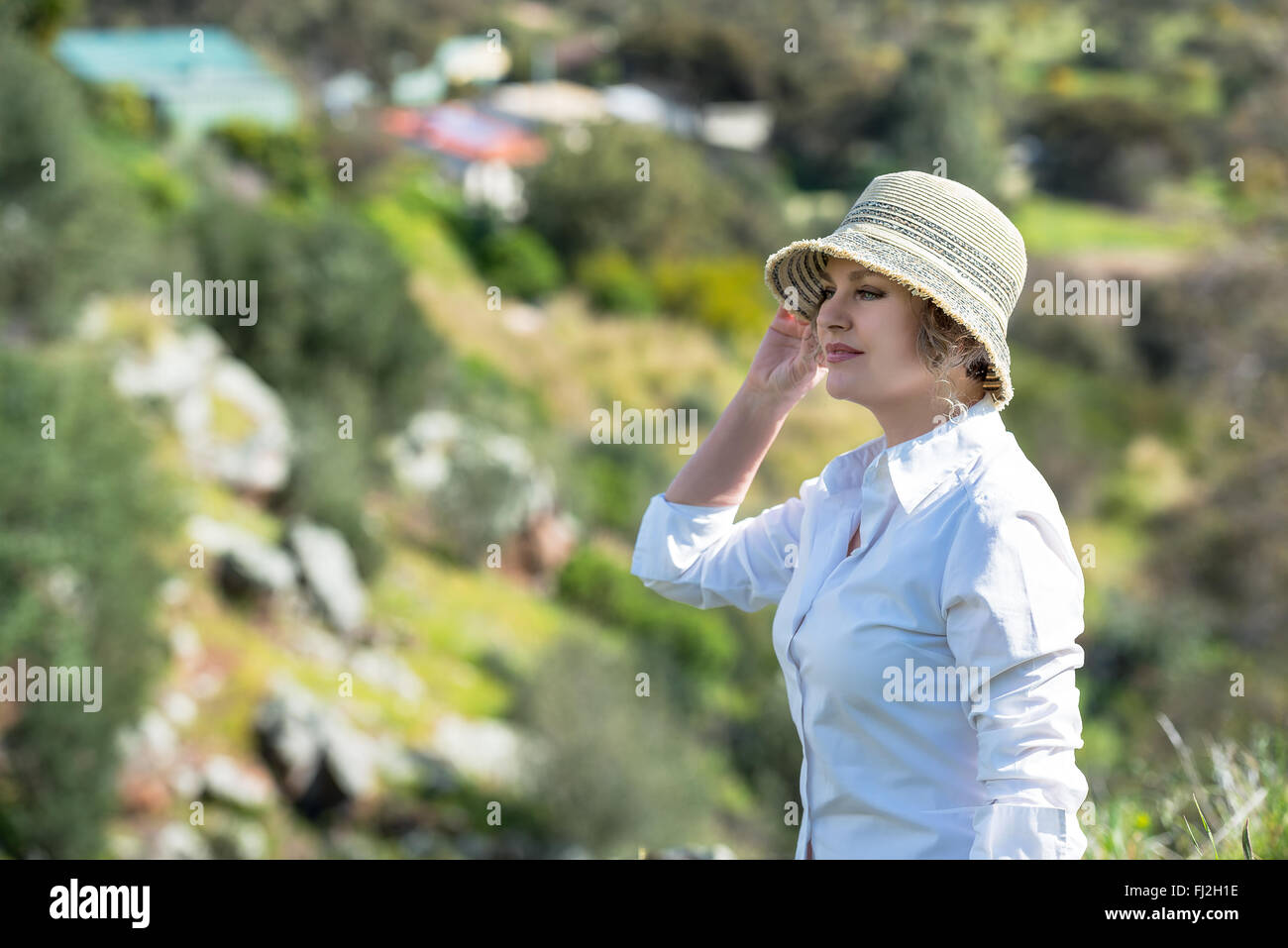 Donna con cappello di godimento nella natura e guardando lontano Foto Stock