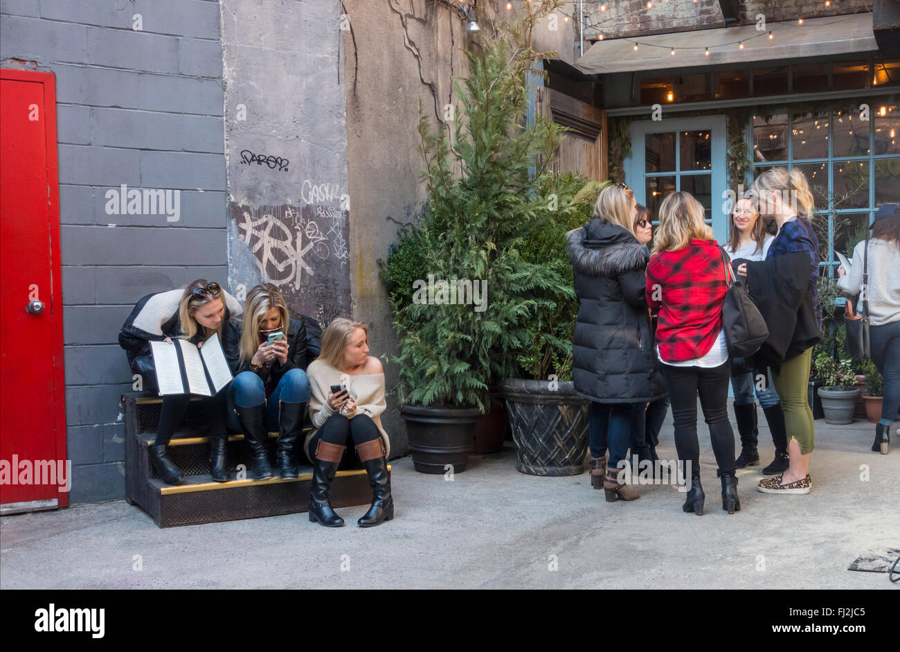 Gruppi di giovani donne in attesa di un tavolo per il brunch presso la Freemans ristorante a la Freemans Alley di New York City Foto Stock