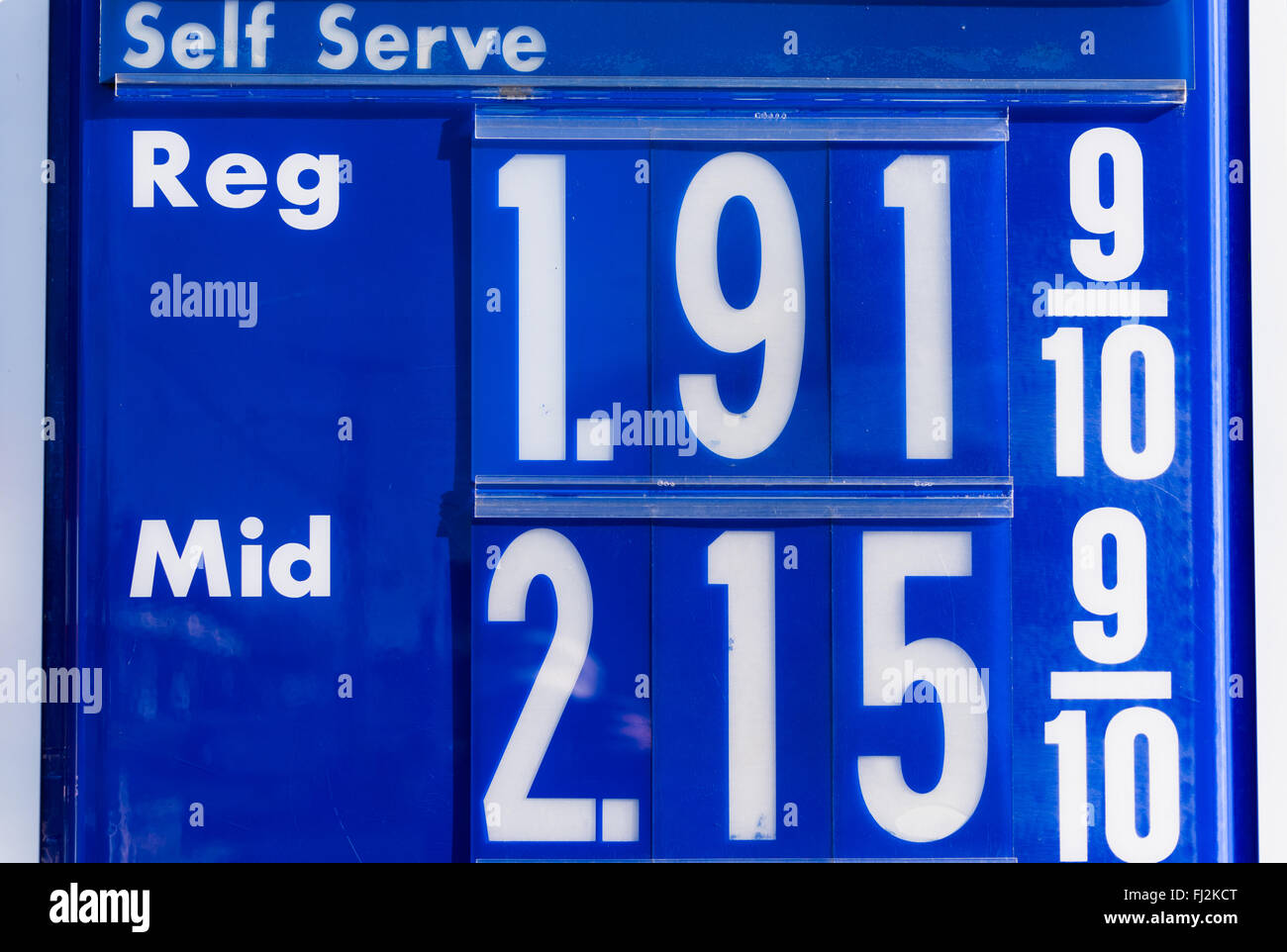 Segnale dei prezzi della benzina Stazione di servizio Stati Uniti | STATI UNITI — Primo piano di un cartello dei prezzi di una stazione di servizio che mostra la benzina self-service regolare a 1,91 9/10 e la benzina di medio grado a 2,15 9/10 al gallone. I cartelli stradali dei prezzi come questo tracciano le fluttuazioni giornaliere dei costi all'ingrosso del carburante, e la tariffa frazionaria di 9/10 di centesimo è una convenzione di vendita al dettaglio statunitense di lunga data per il carburante, che risale alle tasse statali sulla benzina dell'inizio del XX secolo. Foto Stock