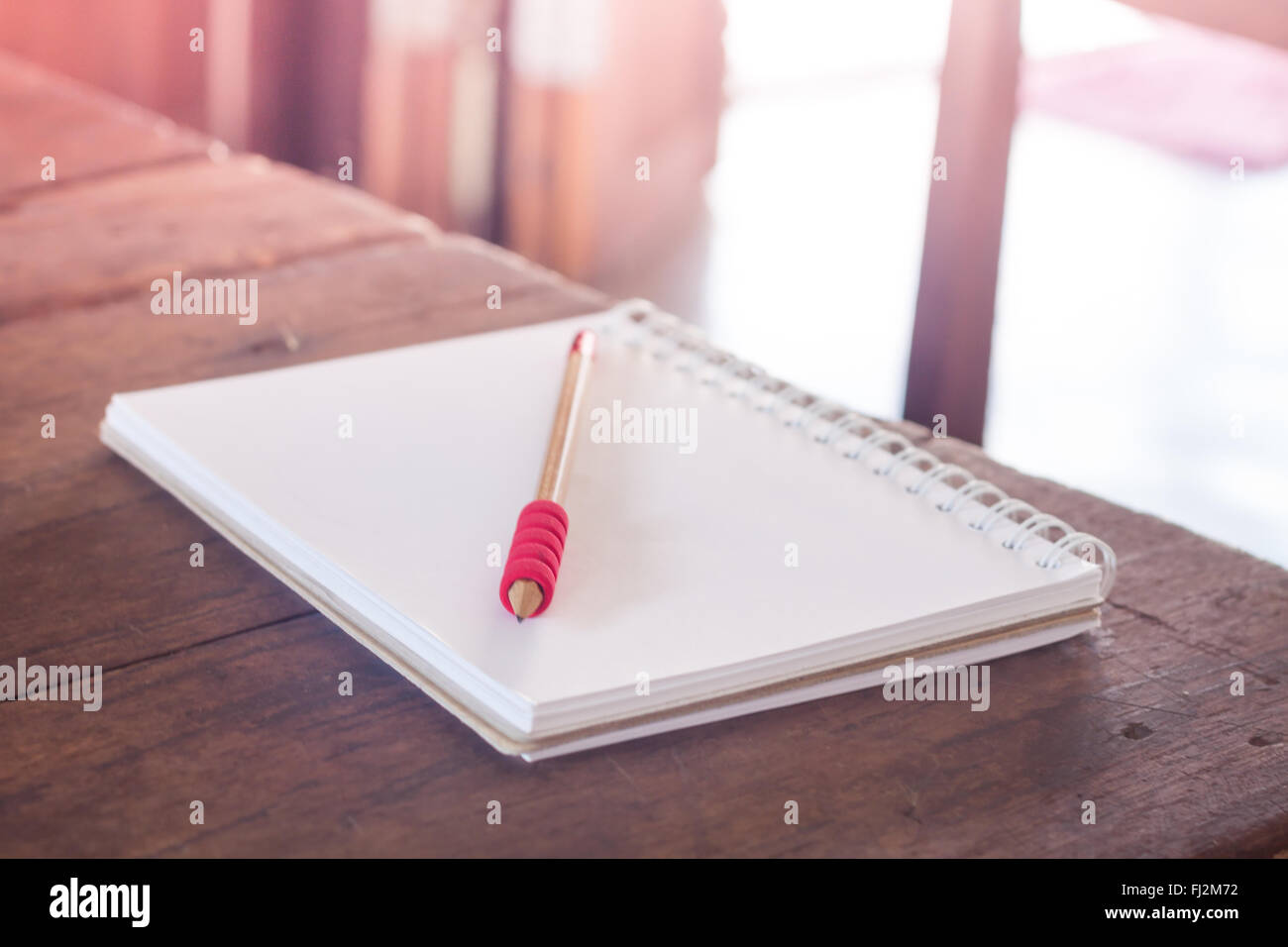 Stazione di lavoro con notebook e matita con filtro vintage, stock photo Foto Stock