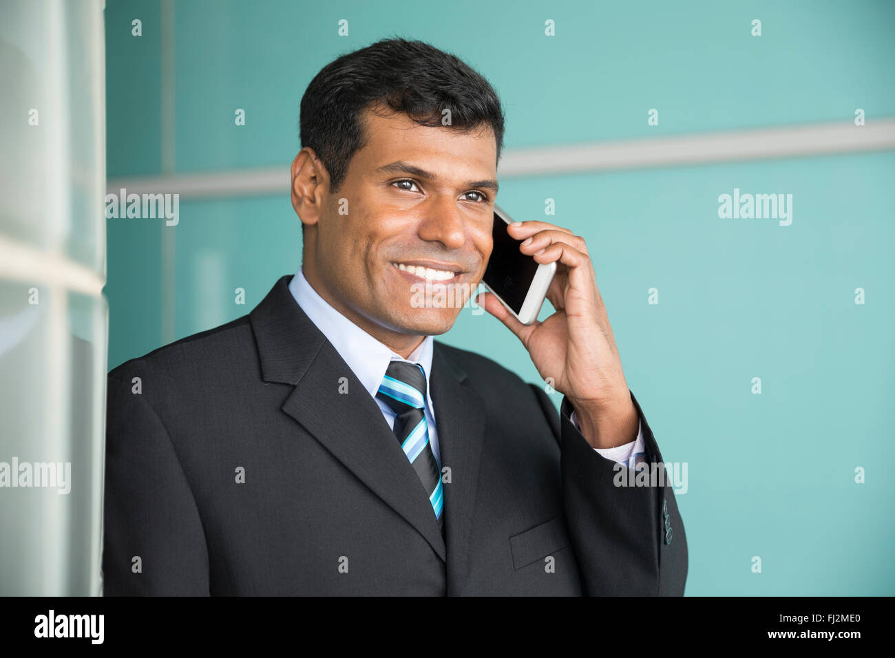 Indian business man con il suo smart phone. Foto Stock