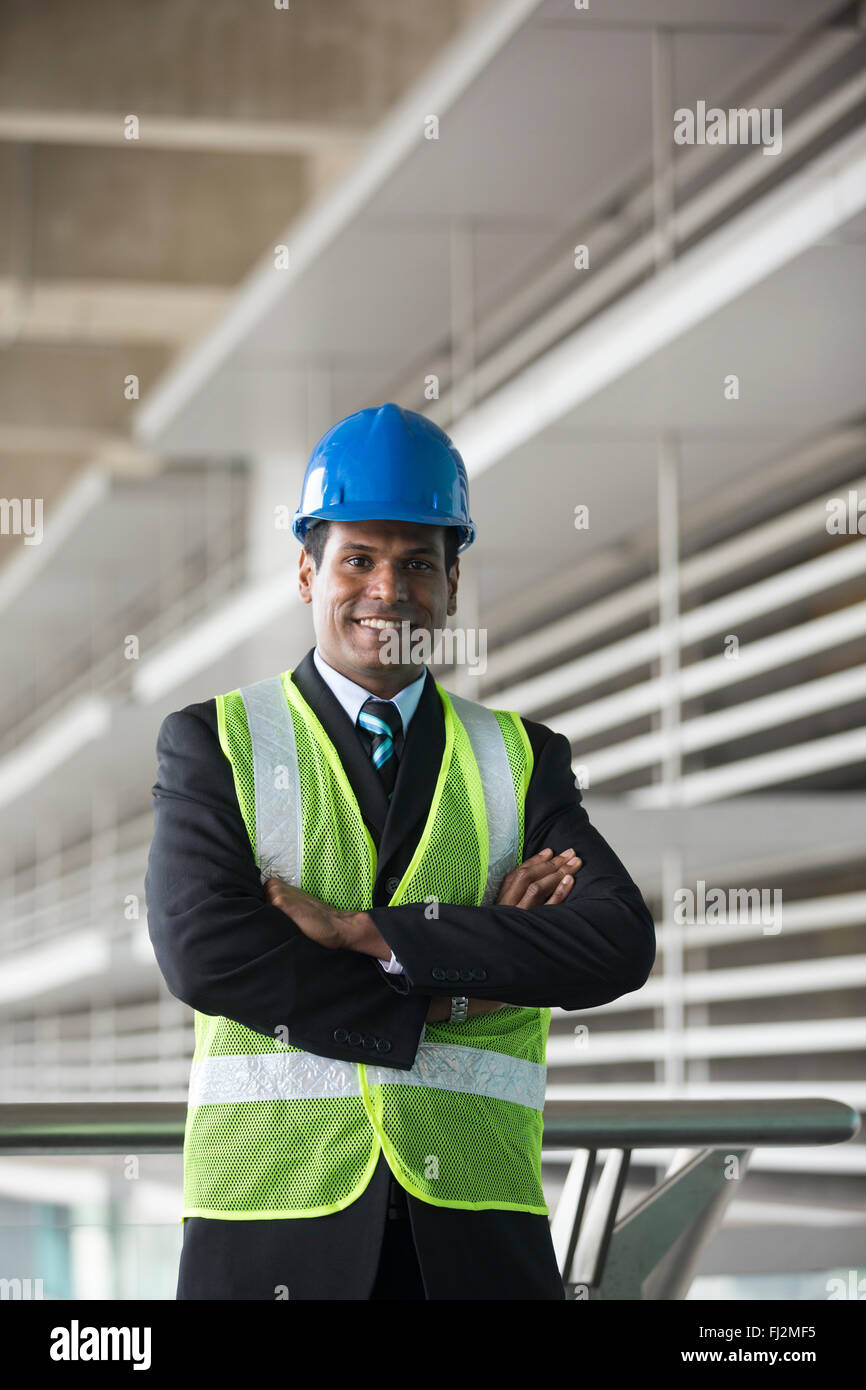 Ritratto di un maschio di indiani, ingegnere industriale al lavoro. Ingegnere asiatici sorridente e guardando la telecamera. Foto Stock