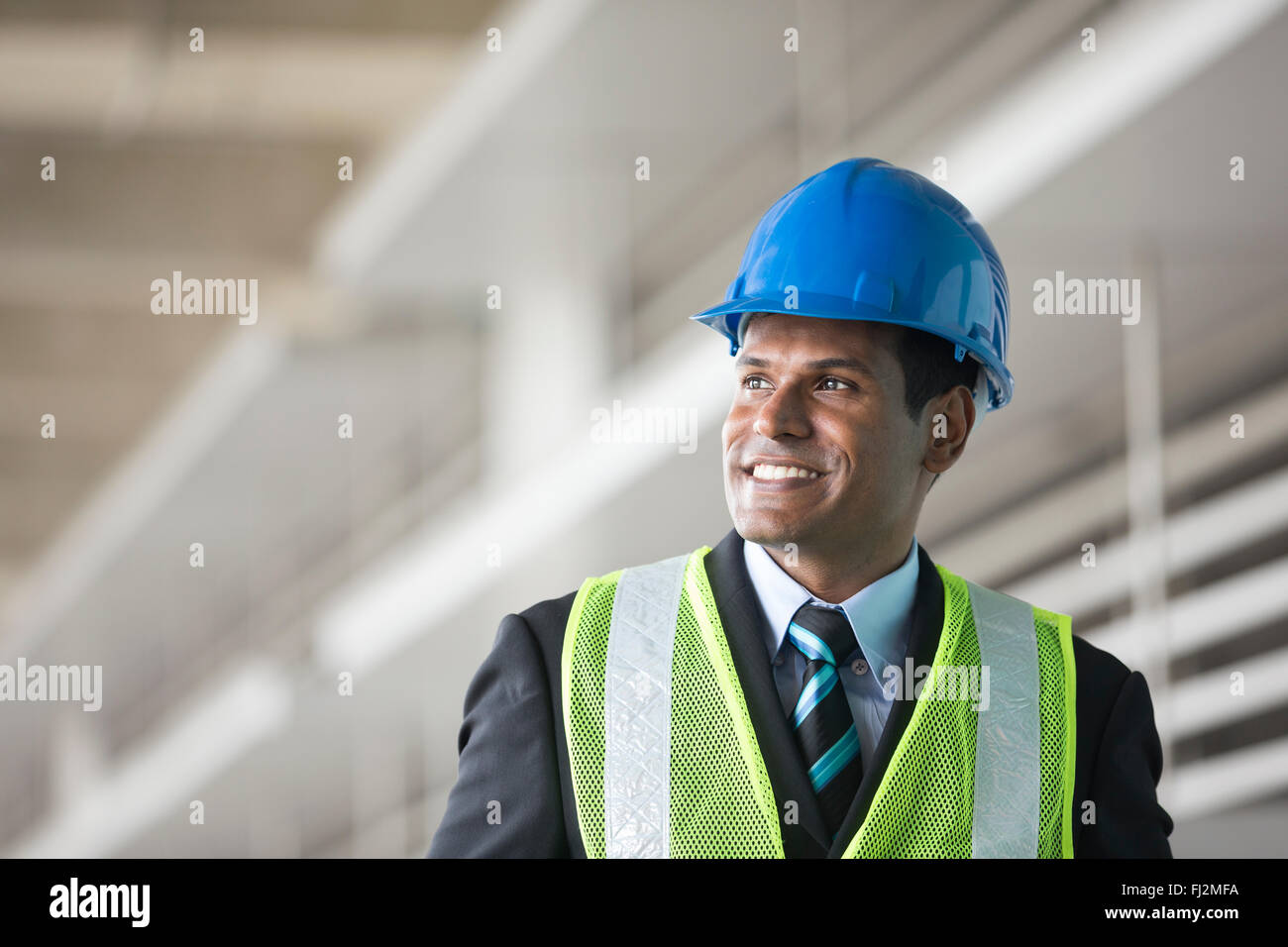 Ritratto di un maschio di indiani, ingegnere industriale al lavoro. Ingegnere asiatici sorridente e guardando la telecamera. Foto Stock