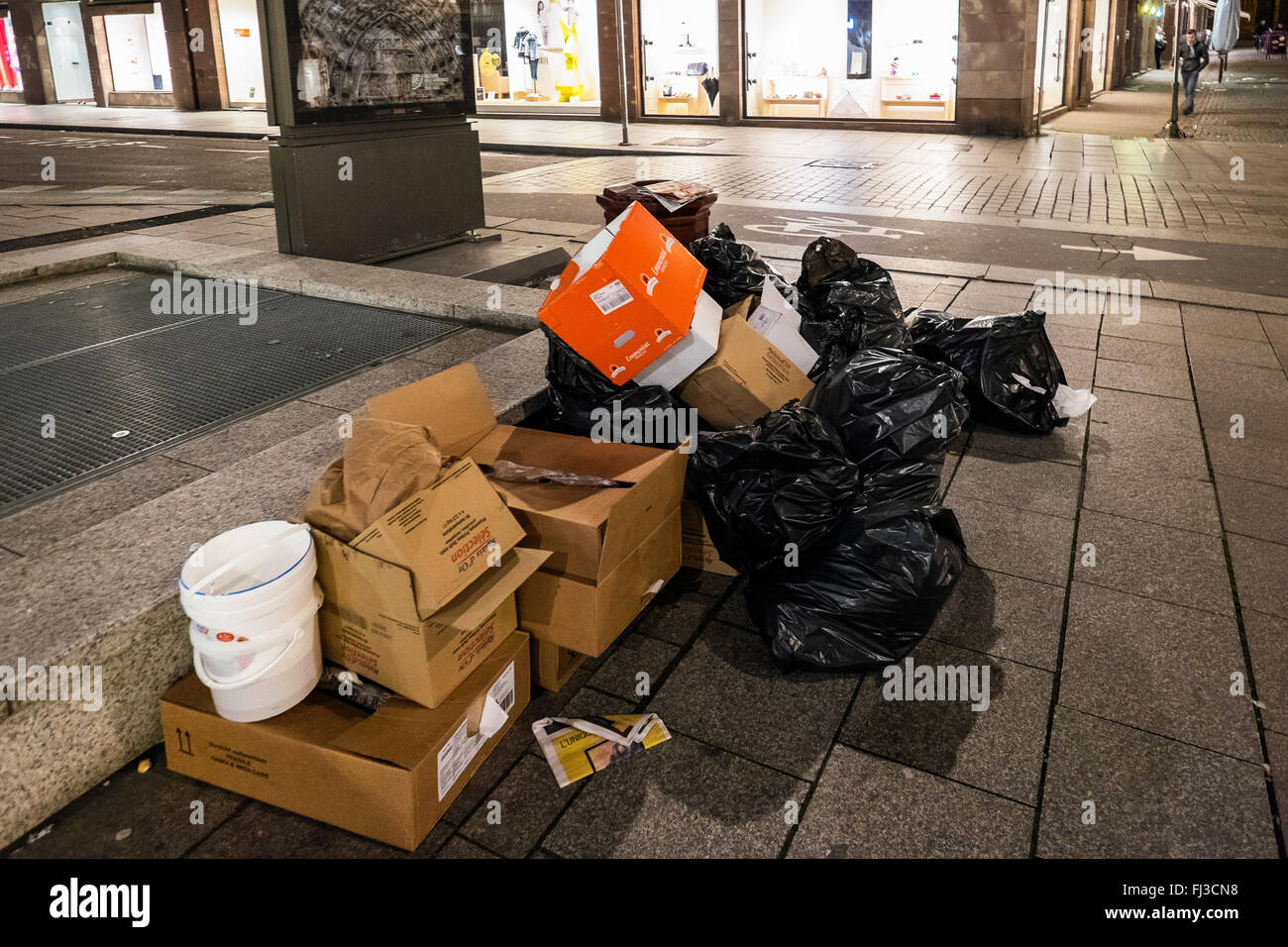 La spazzatura in attesa di raccolta sul marciapiede di notte, Strasburgo, Alsazia, Francia Europa Foto Stock